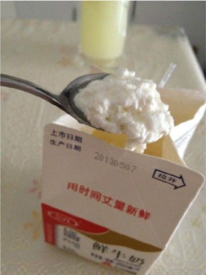 图为李先生购买的三元牛奶,已经变成豆腐脑状物质,并散发算臭味。(图片来源:中国经济网)
