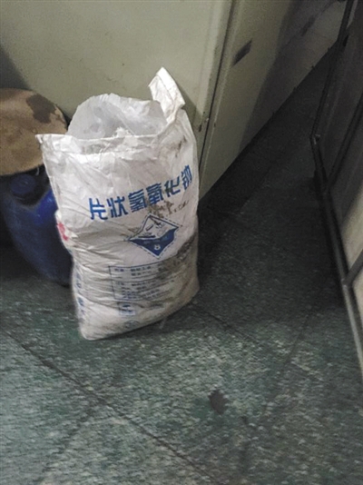 大灰厂村洗涤厂,一袋25公斤的火碱堆在洗衣机旁。